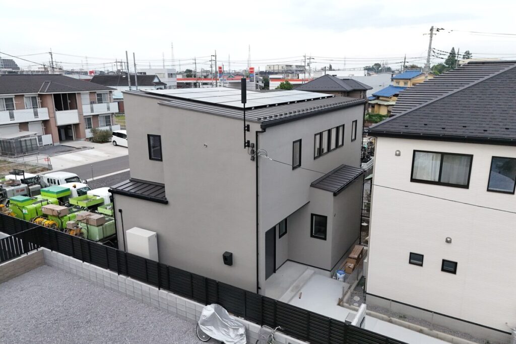 屋根に太陽光パネルを搭載した、グレーの吹き付け外壁がスタイリッシュなモダンな注文住宅