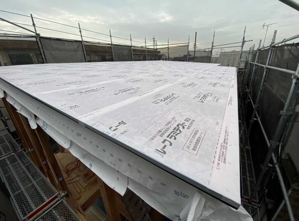 屋根の仕上げ前に施工された、遮熱性能を持つ白いルーフィング(防水シート)の全景