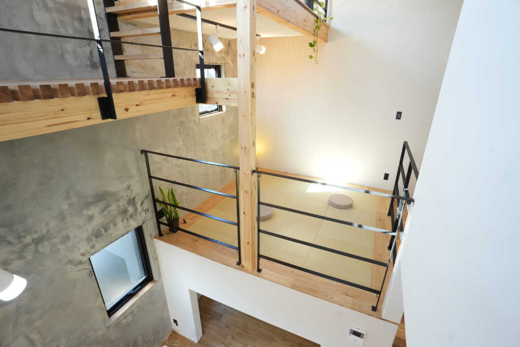 吹き抜けを横断する木製キャットウォークと、その下に広がる畳スペースの俯瞰